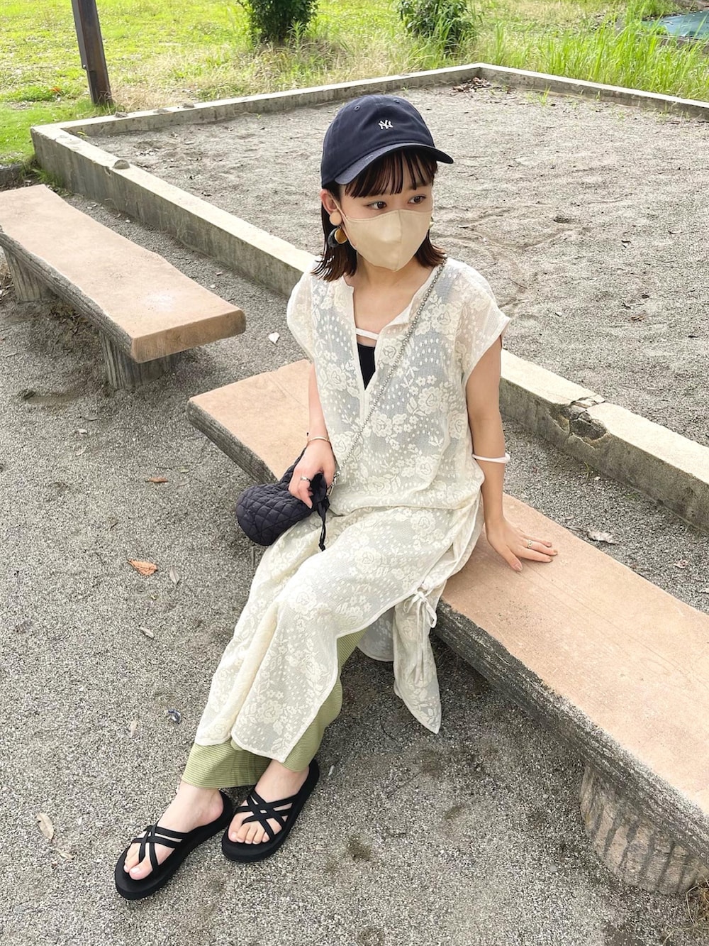 ホワイト系のワンピース、グリーン系のその他パンツ、ブラック系のショルダーバッグを着用したレディースの夏コーディネートの2枚目の写真