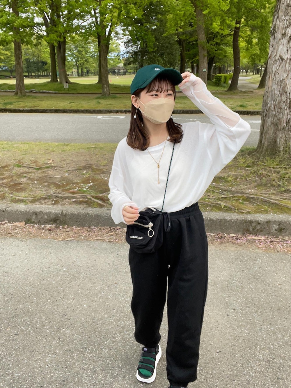 ホワイト系のTシャツ/カットソー、ブラック系のスウェットパンツ、ブラック系のショルダーバッグを着用したレディースの春コーディネートの3枚目の写真