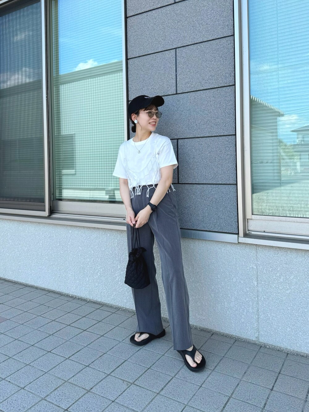 ホワイト系のベスト、ブラック系のサンダル、ホワイト系のTシャツ/カットソーを着用したレディースの夏コーディネートの5枚目の写真