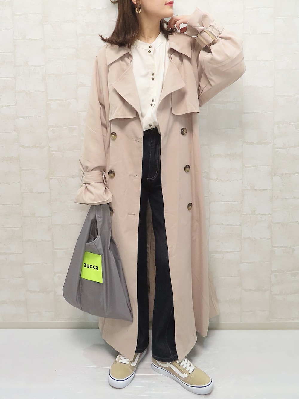 ピンク系のトレンチコート、ベージュ系のシャツ/ブラウス、ブルー系のデニムパンツを着用したレディースの冬コーディネートの2枚目の写真