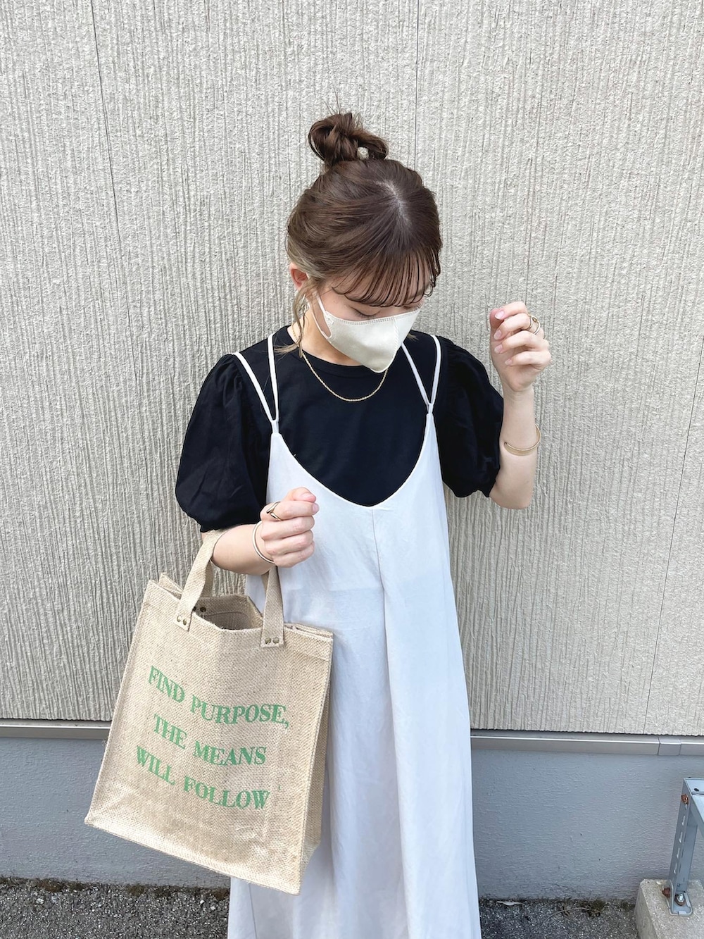 ブラック系のTシャツ/カットソー、ベージュ系のワンピース、グリーン系のバッグを着用したレディースの春コーディネートの3枚目の写真