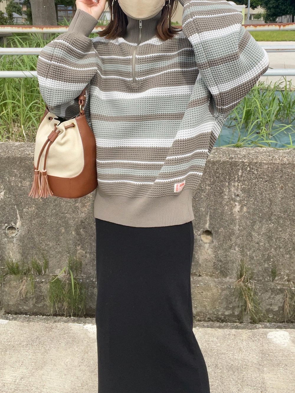 ブルー系のニット/セーター、ブラック系のワンピース、ブラウン系のショルダーバッグを着用したレディースの秋コーディネートの5枚目の写真