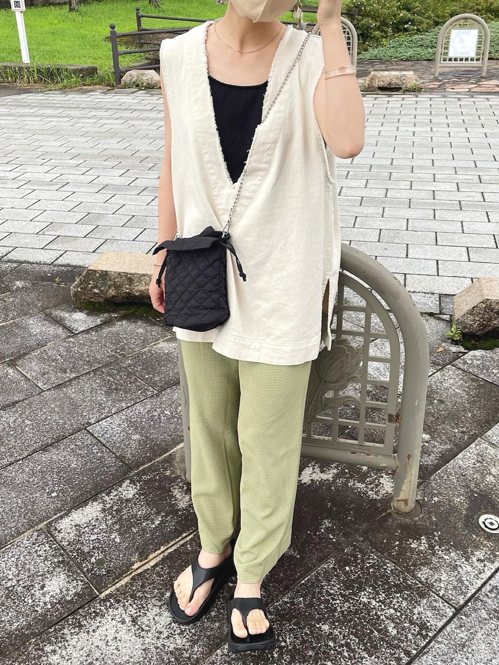 グリーン系のその他パンツ、ホワイト系のベスト、ブラック系のショルダーバッグを着用したレディースの夏コーディネートの5枚目の写真