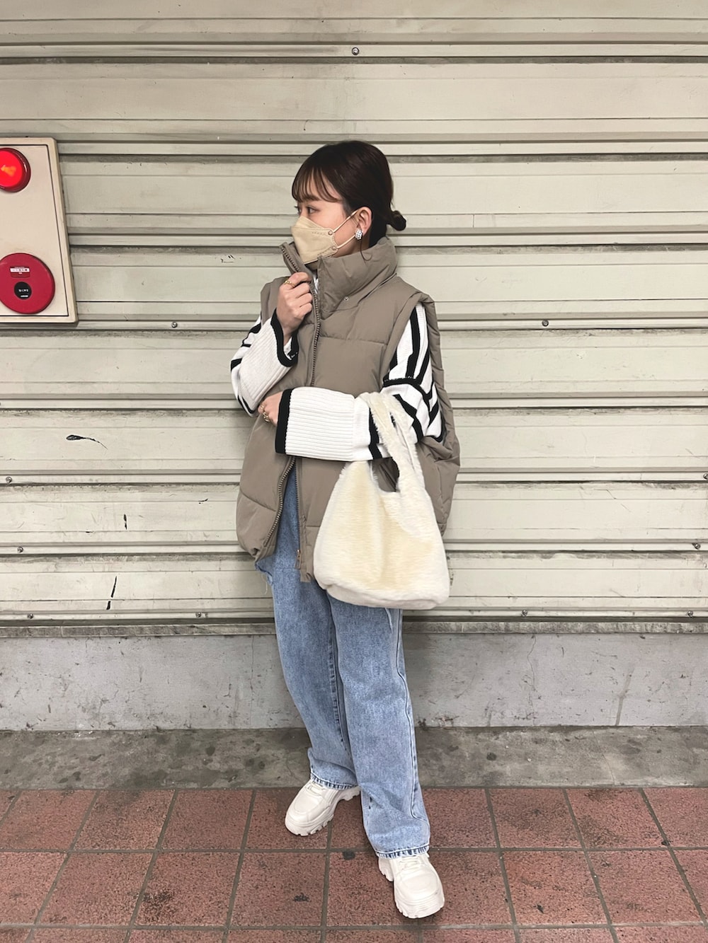 ホワイト系のニット/セーター、その他のデニムパンツ、ベージュ系のダウンベストを着用したレディースの冬コーディネートの2枚目の写真