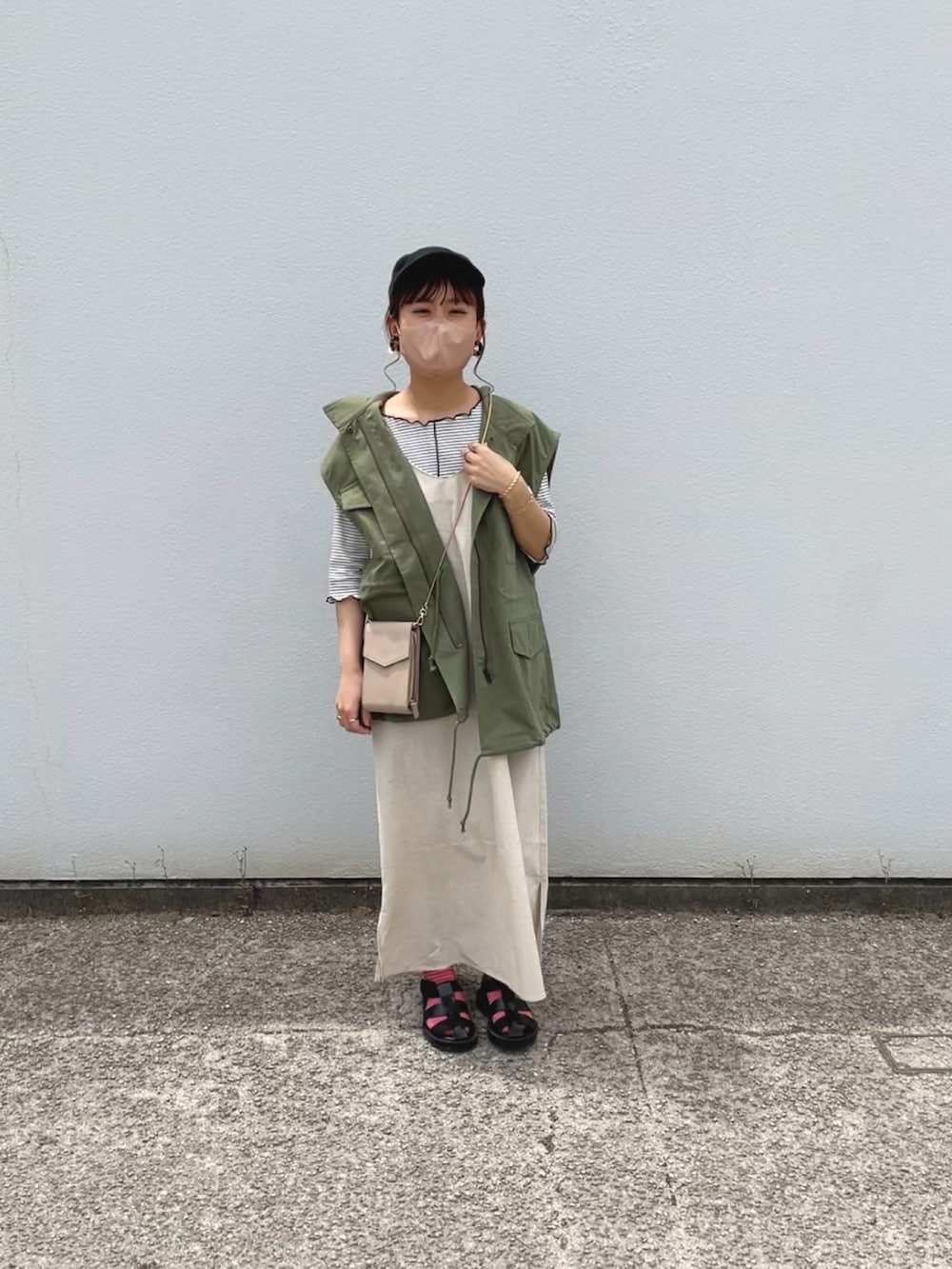 グリーン系のワンピース、ホワイト系のTシャツ/カットソー、グリーン系のベストを着用したレディースの春コーディネートの4枚目の写真