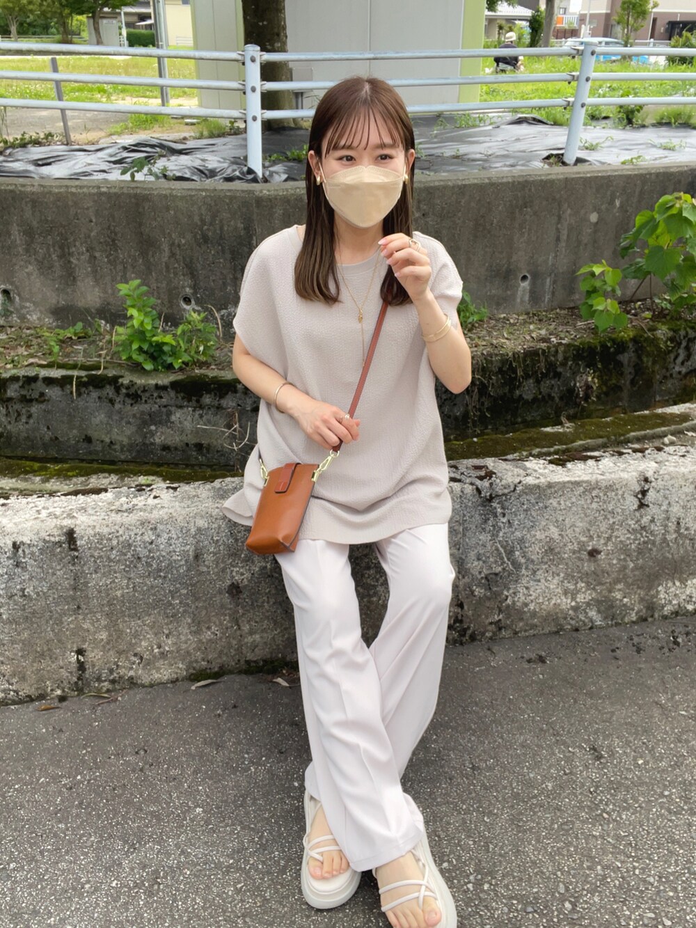 ベージュ系のTシャツ/カットソー、ホワイト系のその他パンツ、ブラウン系のショルダーバッグを着用したレディースの夏コーディネートの3枚目の写真