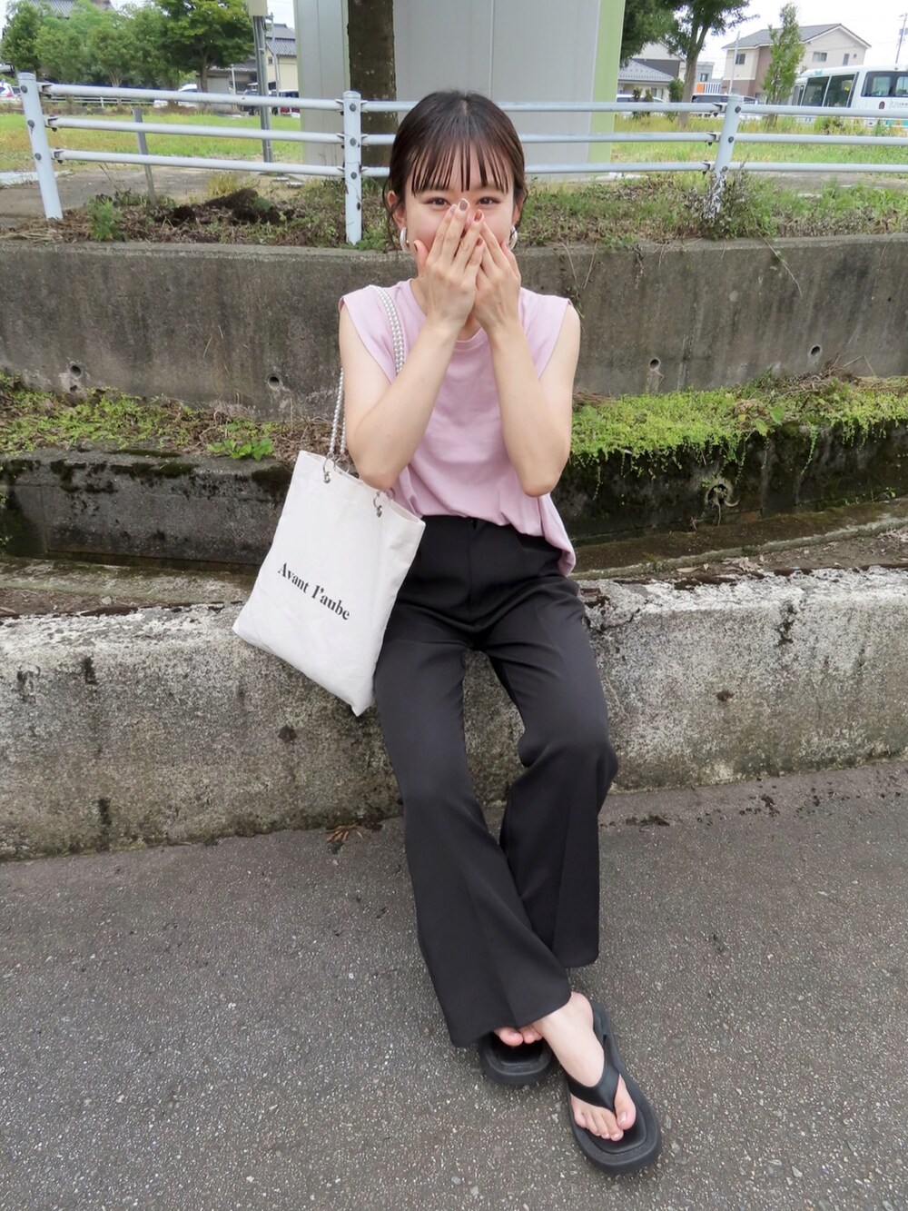 ピンク系のTシャツ/カットソー、ブラック系のスラックス、ホワイト系のトートバッグを着用したレディースの夏コーディネートの2枚目の写真