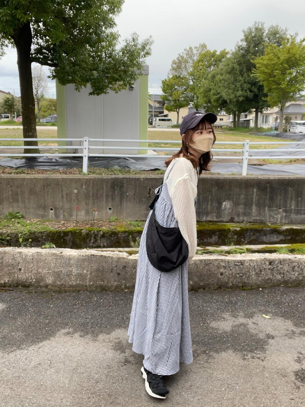 ホワイト系のワンピース、ベージュ系のTシャツ/カットソー、ブラック系のキャミソールを着用したレディースの春コーディネートの3枚目の写真