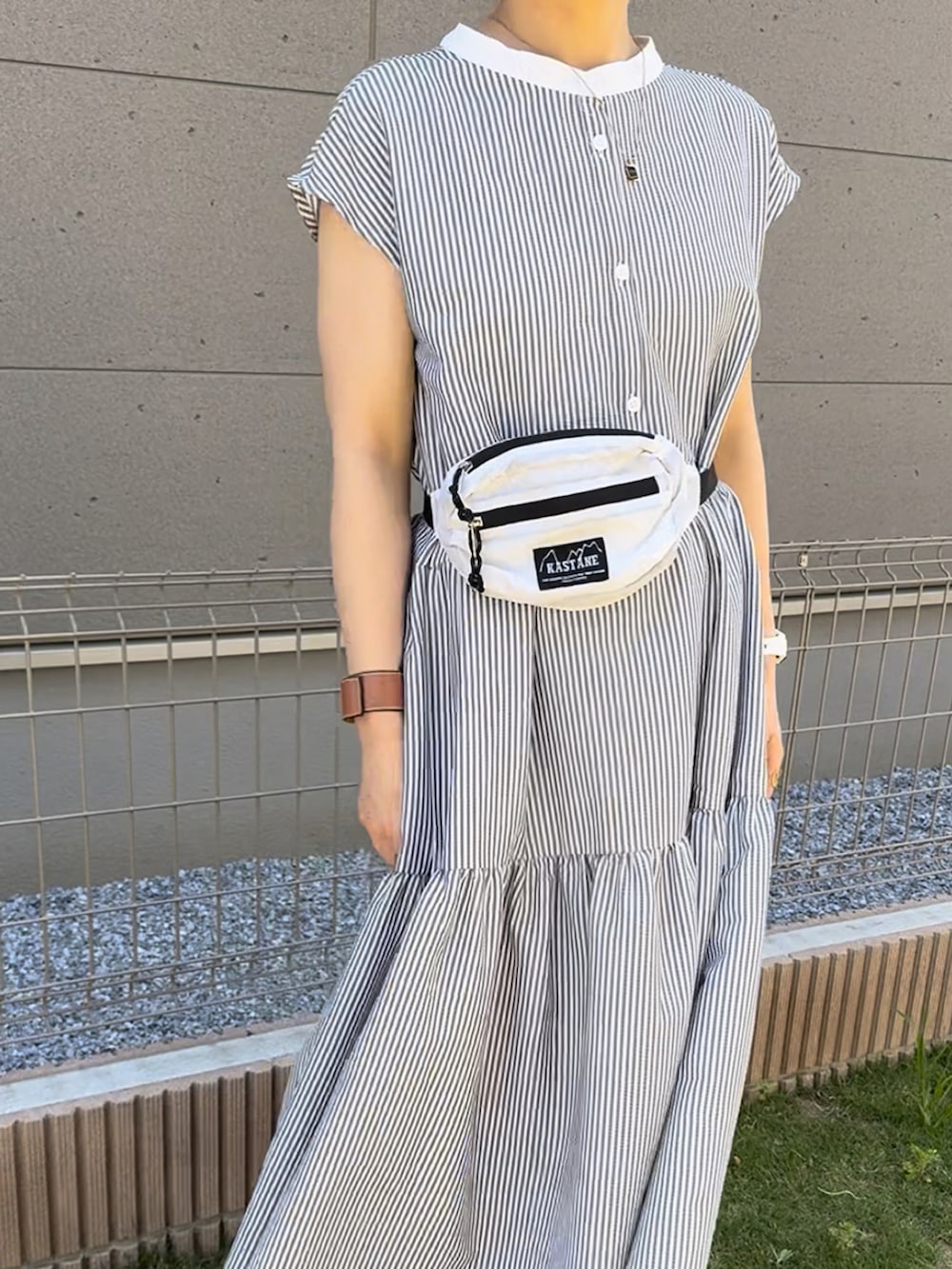 ブラック系のワンピース、ブラック系のサンダル、ブラウン系のキャップを着用したレディースの夏コーディネートの4枚目の写真