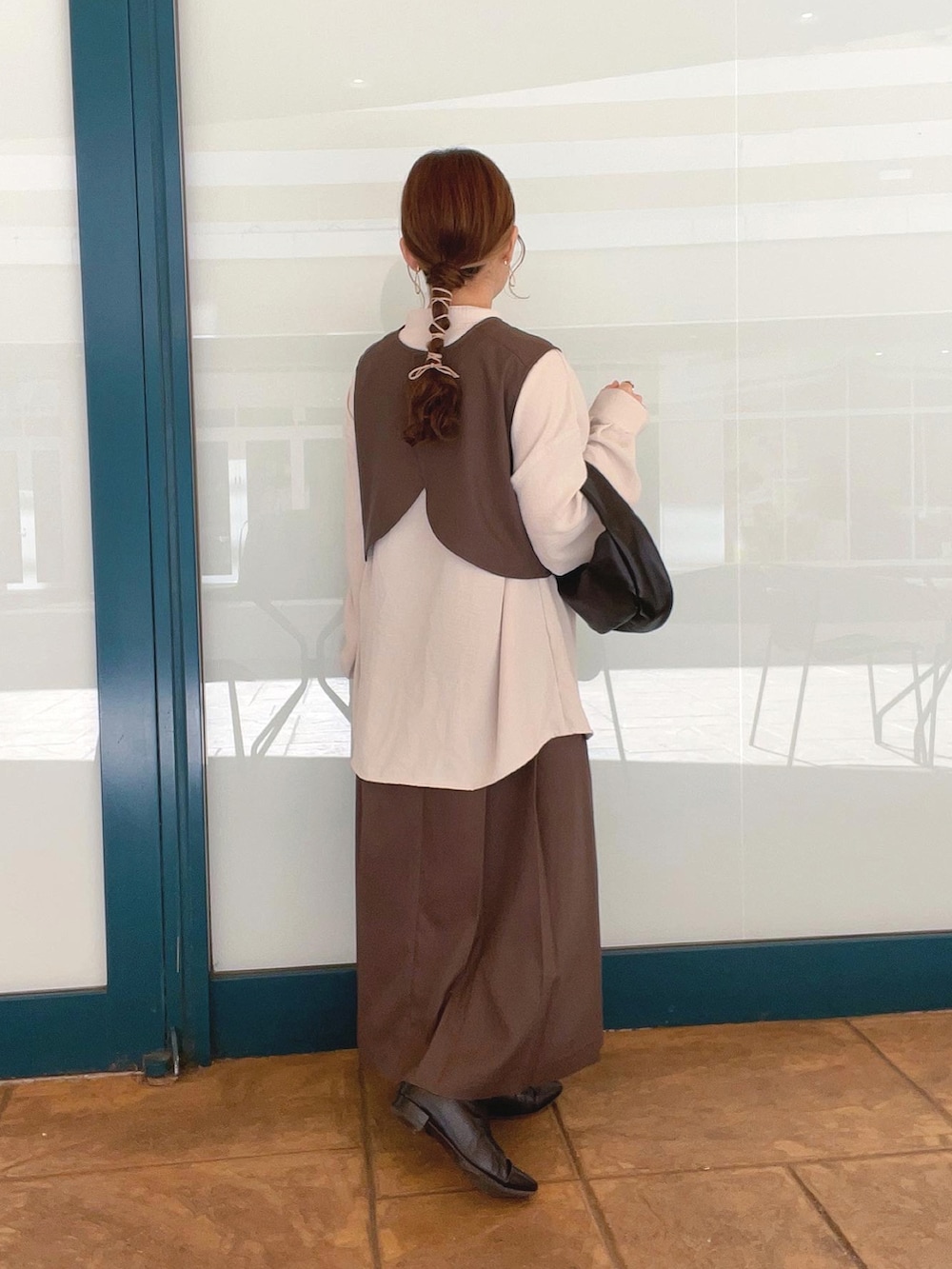 ブラウン系のワンピース、ホワイト系のシャツ/ブラウス、ブラック系のハンドバッグを着用したレディースの秋コーディネートの2枚目の写真