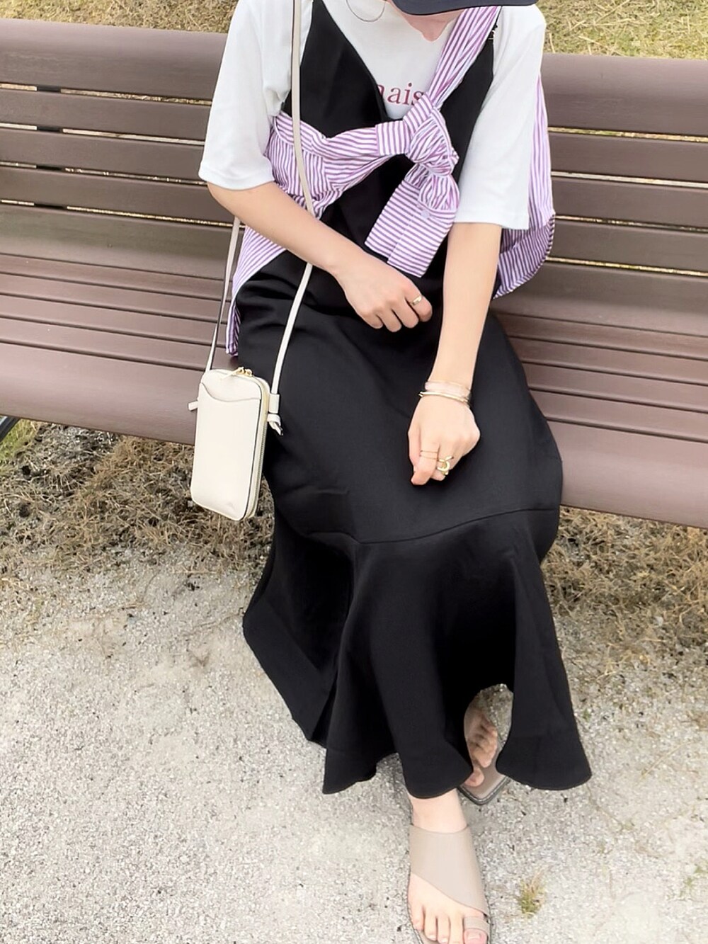 ピンク系のシャツ/ブラウス、ブラック系のジャンパースカート、ホワイト系のバッグを着用したレディースの夏コーディネートの3枚目の写真