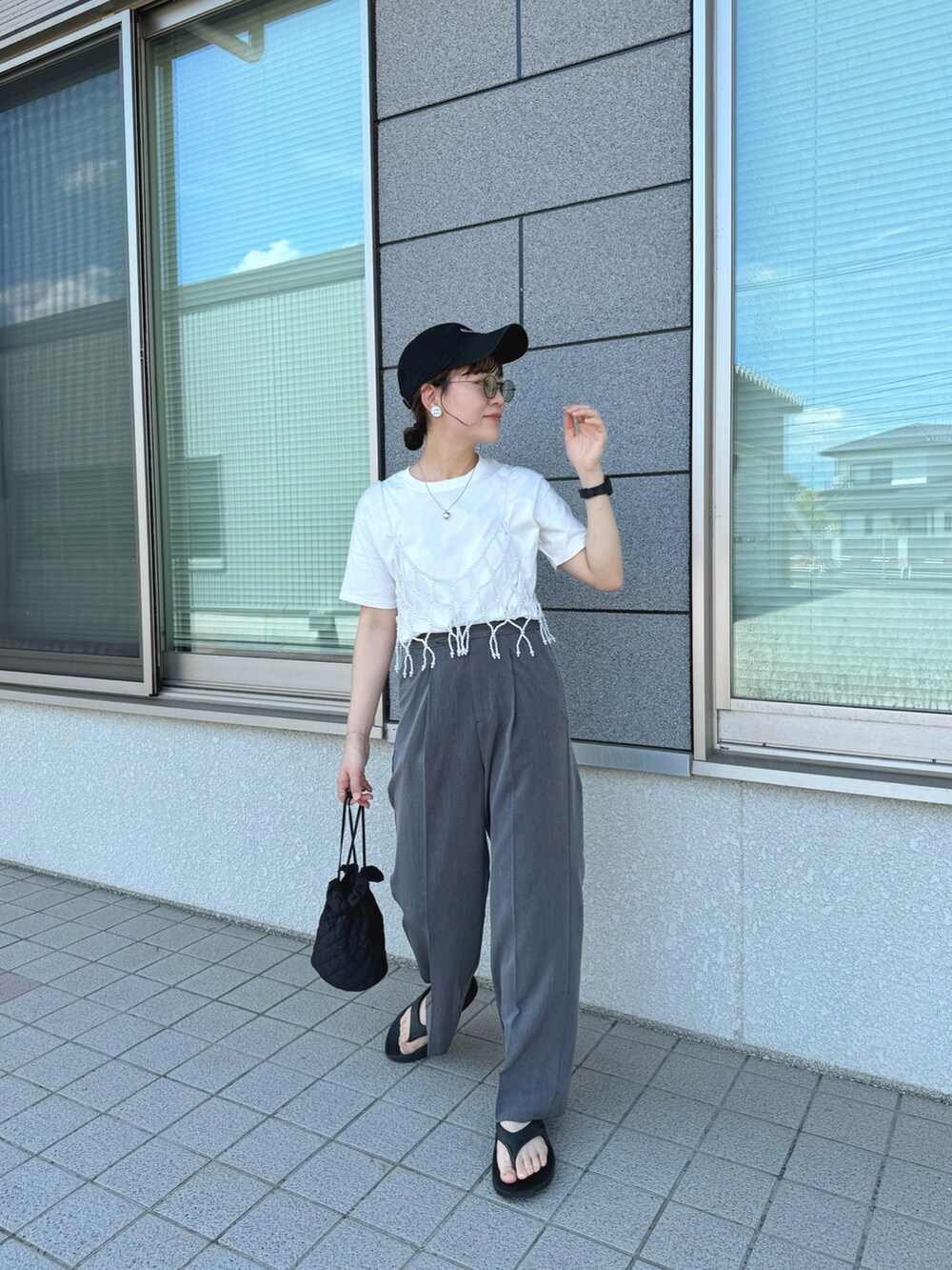 ホワイト系のベスト、ブラック系のサンダル、ホワイト系のTシャツ/カットソーを着用したレディースの夏コーディネートの4枚目の写真