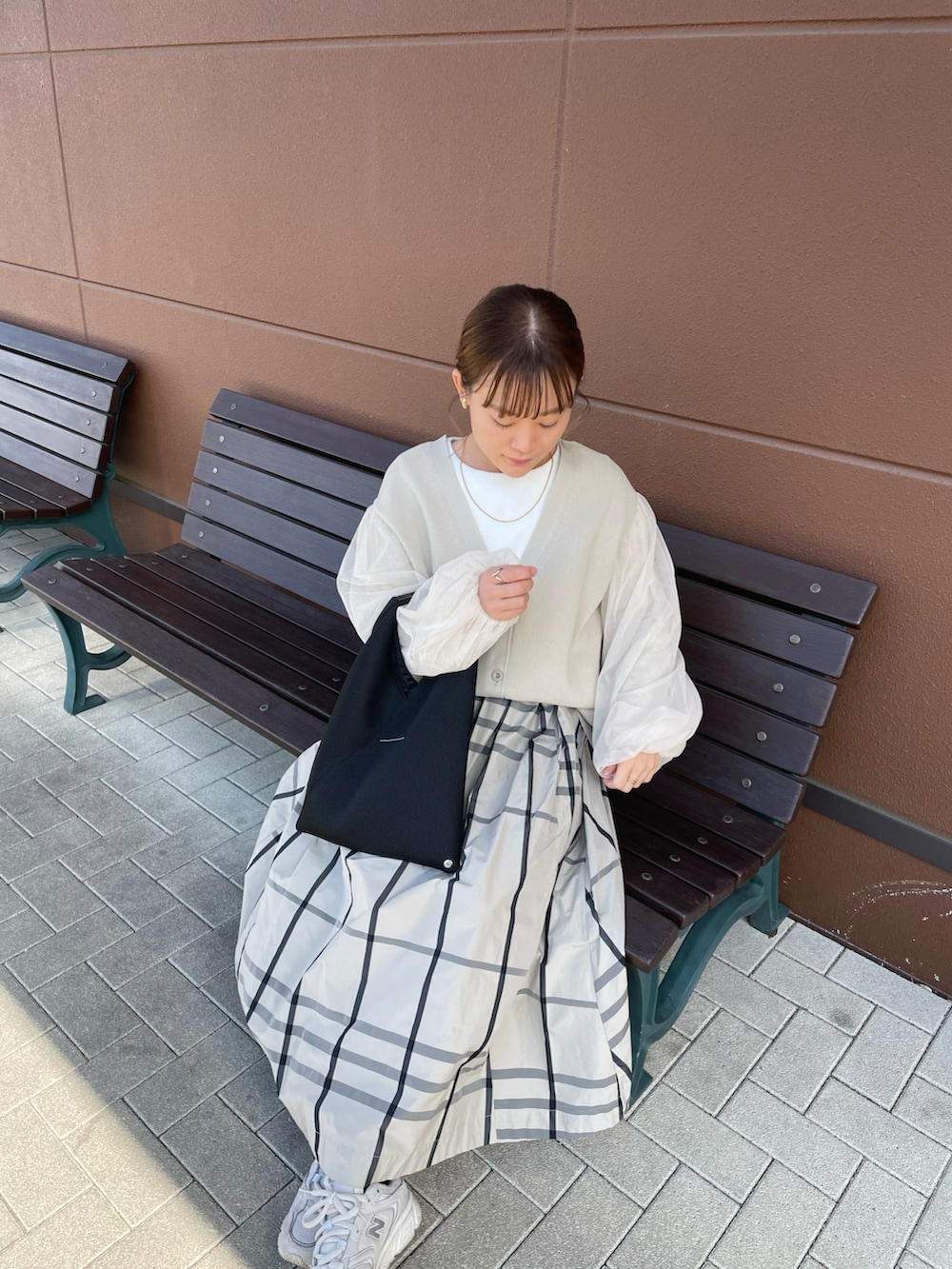 ベージュ系のスカート、ベージュ系のカーディガン/ボレロ、ブラック系のトートバッグを着用したレディースの春コーディネートの3枚目の写真