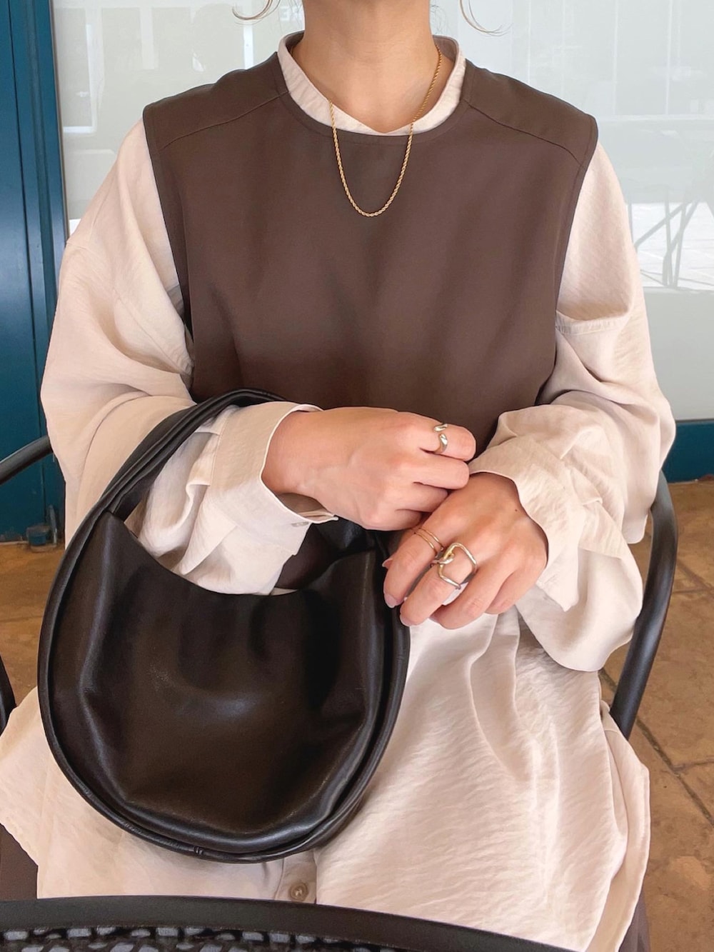 ブラウン系のワンピース、ホワイト系のシャツ/ブラウス、ブラック系のハンドバッグを着用したレディースの秋コーディネートの5枚目の写真