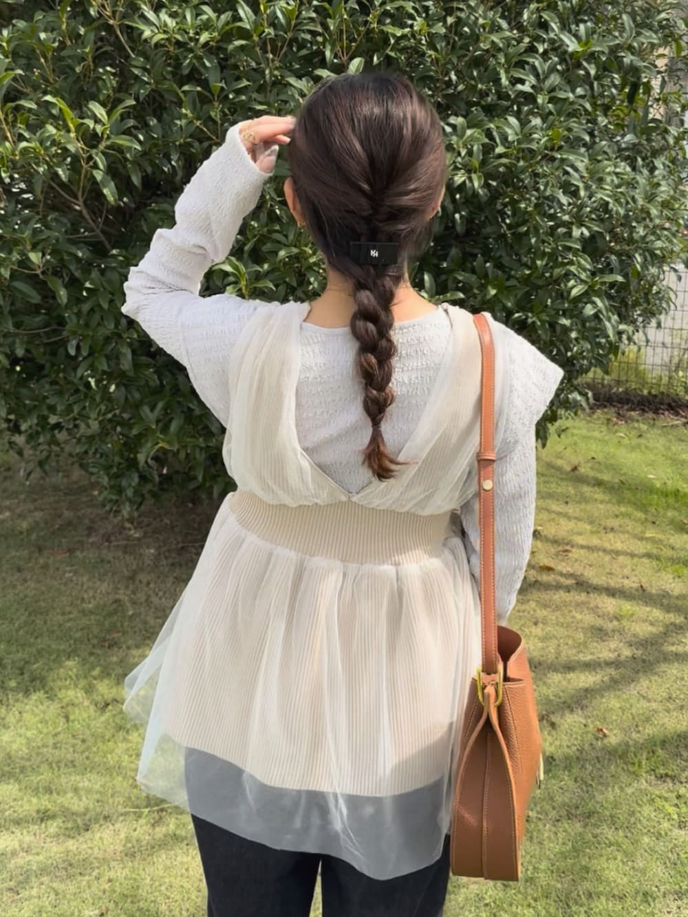 ホワイト系のTシャツ/カットソー、ブラウン系のショルダーバッグ、ベージュ系のベストを着用したレディースの秋コーディネートの2枚目の写真