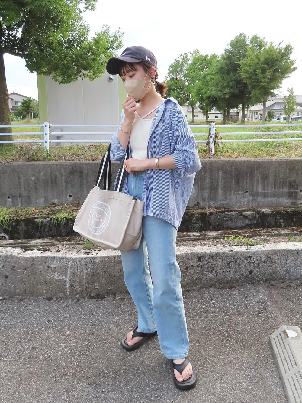 ブルー系のデニムパンツ、ホワイト系のキャミソール、ブルー系のシャツ/ブラウスを着用したレディースの夏コーディネートの2枚目の写真