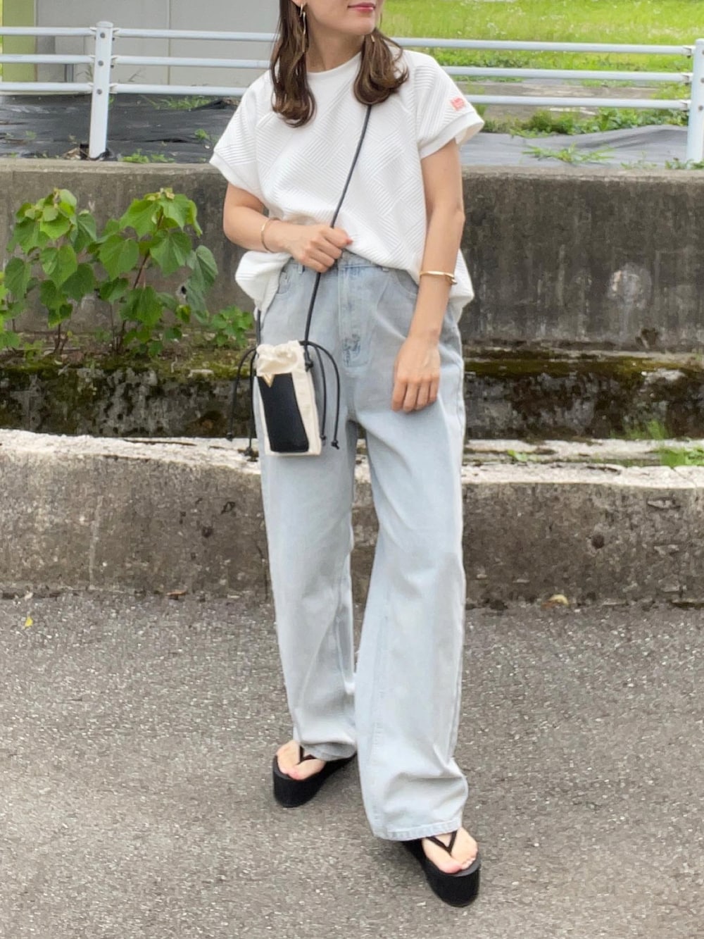 ホワイト系のTシャツ/カットソー、ブルー系のデニムパンツ、ホワイト系のショルダーバッグを着用したレディースの夏コーディネートの4枚目の写真