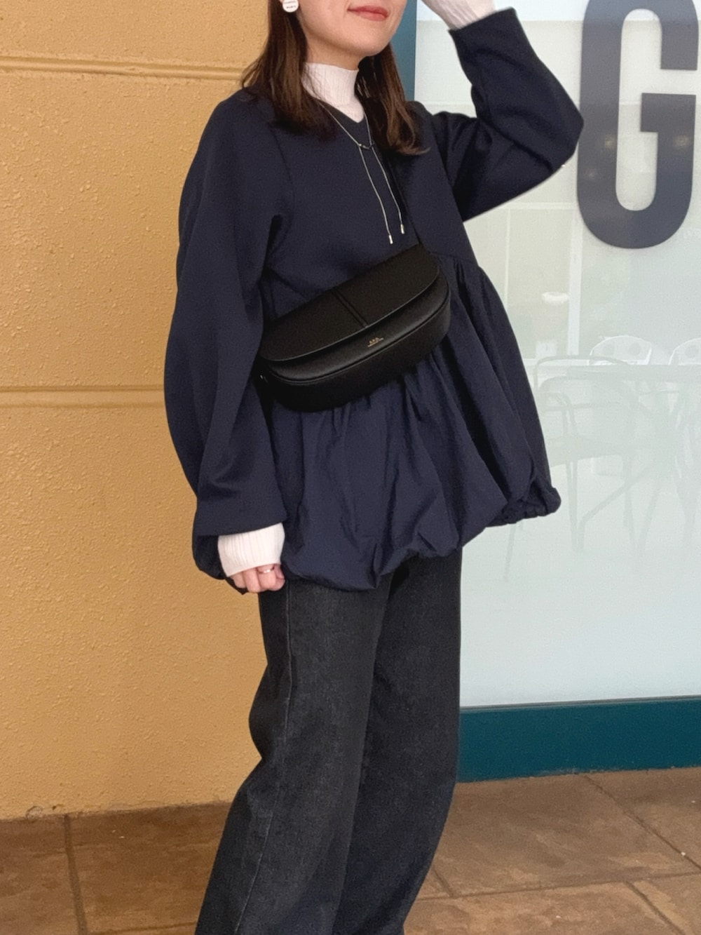 ブルー系のTシャツ/カットソー、ブラック系のデニムパンツ、ブラック系のショルダーバッグを着用したレディースの秋コーディネートの3枚目の写真