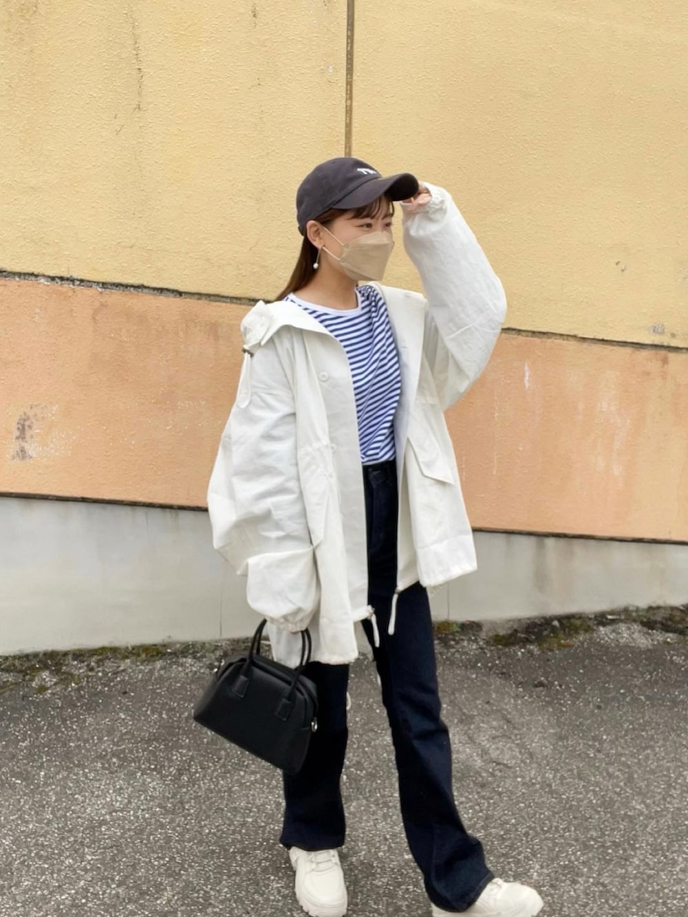 ブルー系のTシャツ/カットソー、ホワイト系のモッズコート、ブルー系のデニムパンツを着用したレディースの春コーディネートの5枚目の写真