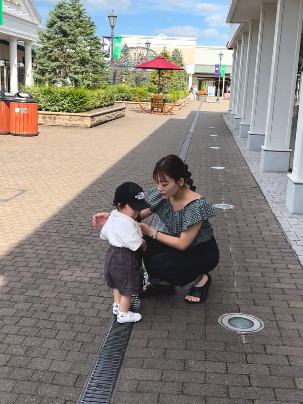 ブラック系のサンダル、グリーン系のトップス、ブラック系のパンツを着用したレディースの夏コーディネートの5枚目の写真