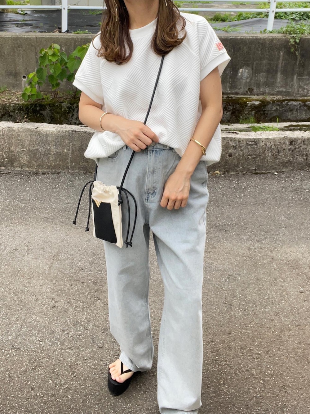ホワイト系のTシャツ/カットソー、ブルー系のデニムパンツ、ホワイト系のショルダーバッグを着用したレディースの夏コーディネートの3枚目の写真