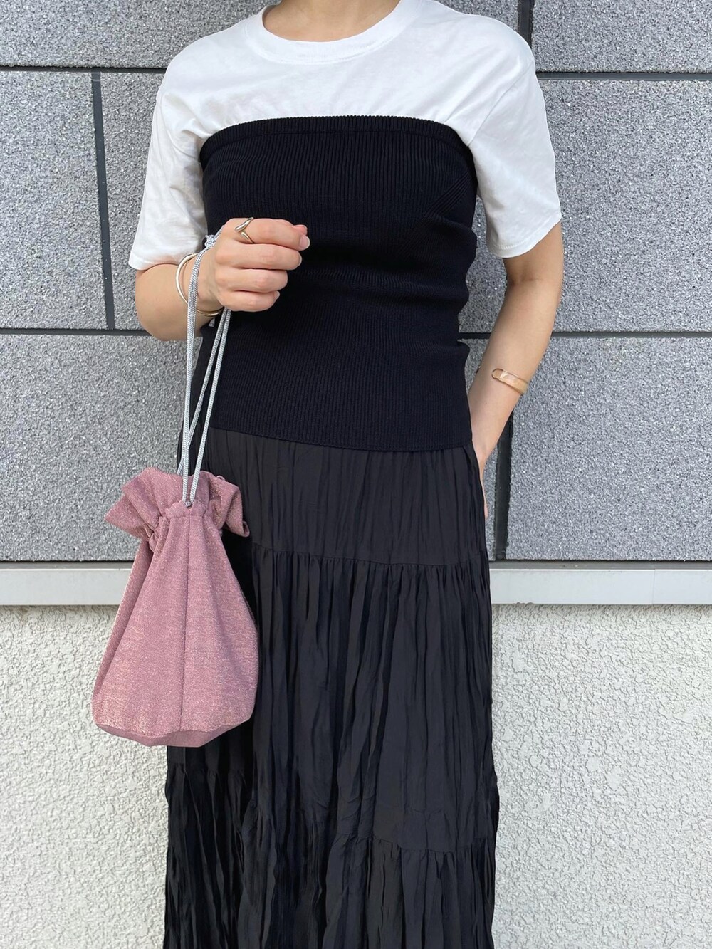 ブラック系のチューブトップ、ブラック系のスカート、ピンク系のショルダーバッグを着用したレディースの夏コーディネートの3枚目の写真