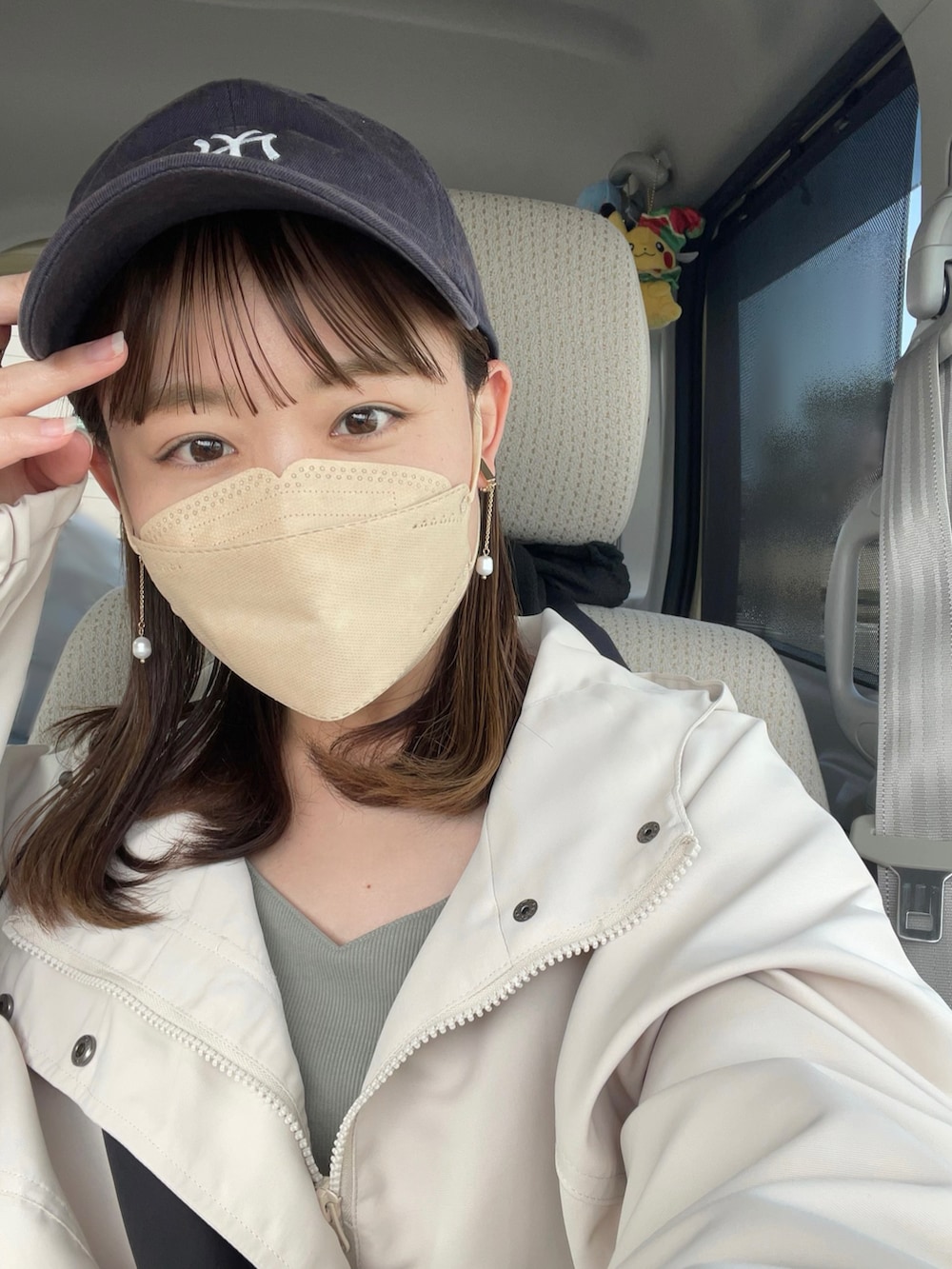 ホワイト系のマウンテンパーカー、グリーン系のワンピース/ドレス、ホワイト系のスニーカーを着用したレディースの春コーディネートの5枚目の写真