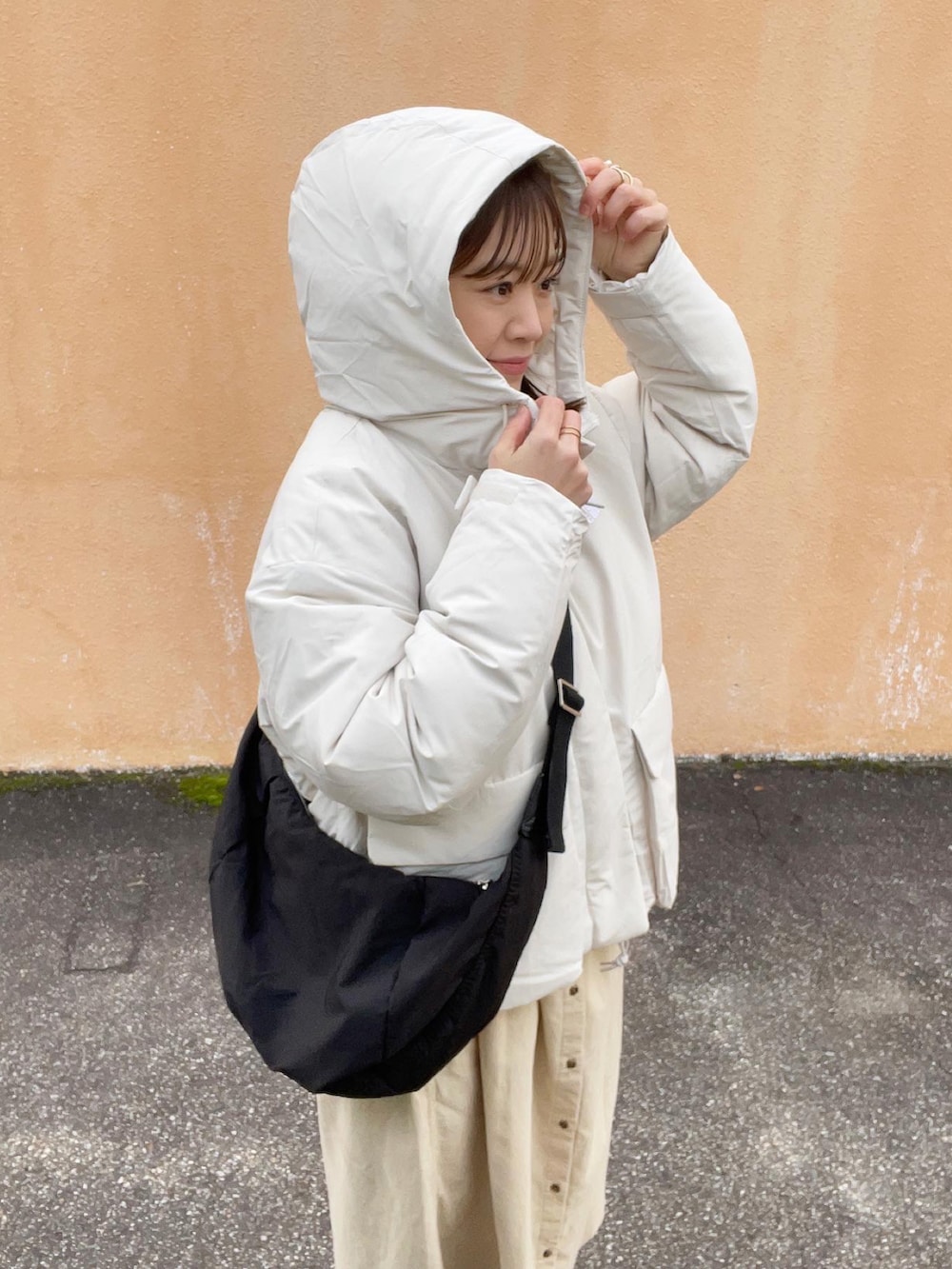 ホワイト系のワンピース、ホワイト系のジャケット/アウター、ブラック系のショルダーバッグを着用したレディースの冬コーディネートの5枚目の写真