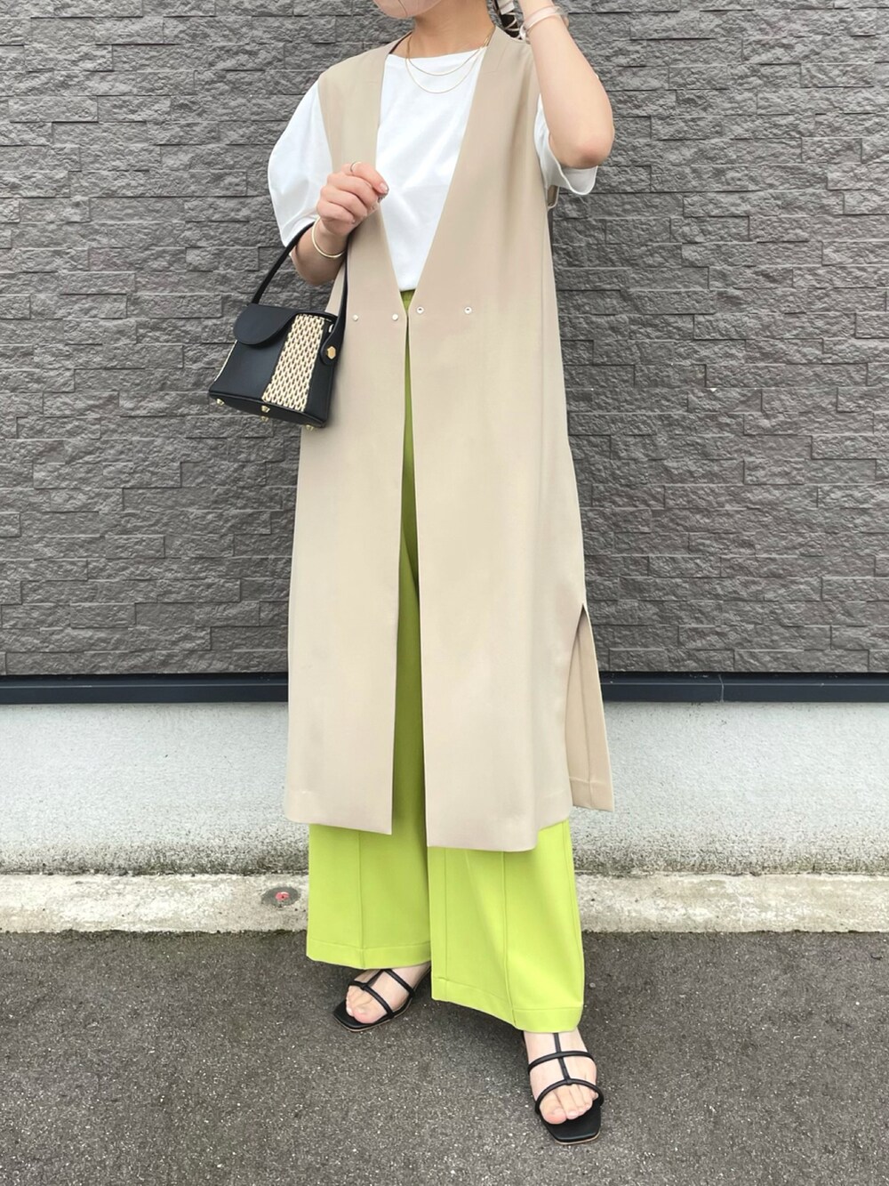 ベージュ系のベスト、グリーン系のその他パンツ、ホワイト系のTシャツ/カットソーを着用したレディースの夏コーディネートの3枚目の写真