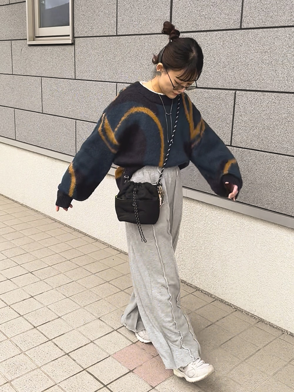 グレー系のスウェットパンツ、ブルー系のニット/セーター、ホワイト系のスニーカーを着用したレディースの冬コーディネートの5枚目の写真