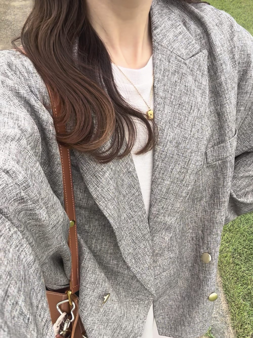 ベージュ系のテーラードジャケット、ベージュ系のワンピース、ブラウン系のショルダーバッグを着用したレディースの秋コーディネートの4枚目の写真