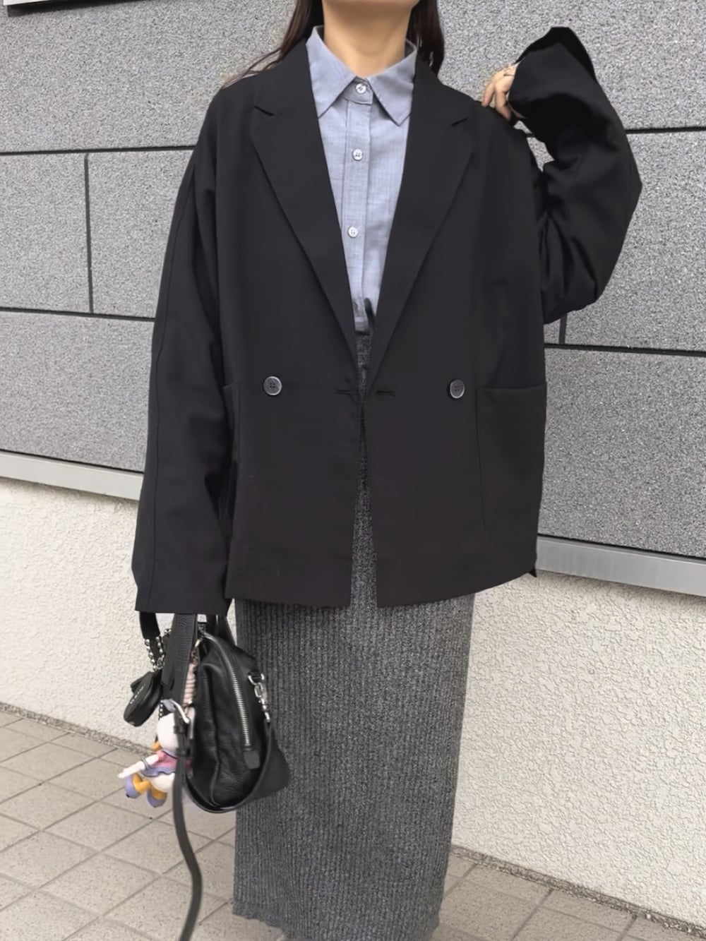 ブラック系のボストンバッグ、ブラック系のテーラードジャケット、ベージュ系のスニーカーを着用したレディースの春コーディネートの4枚目の写真