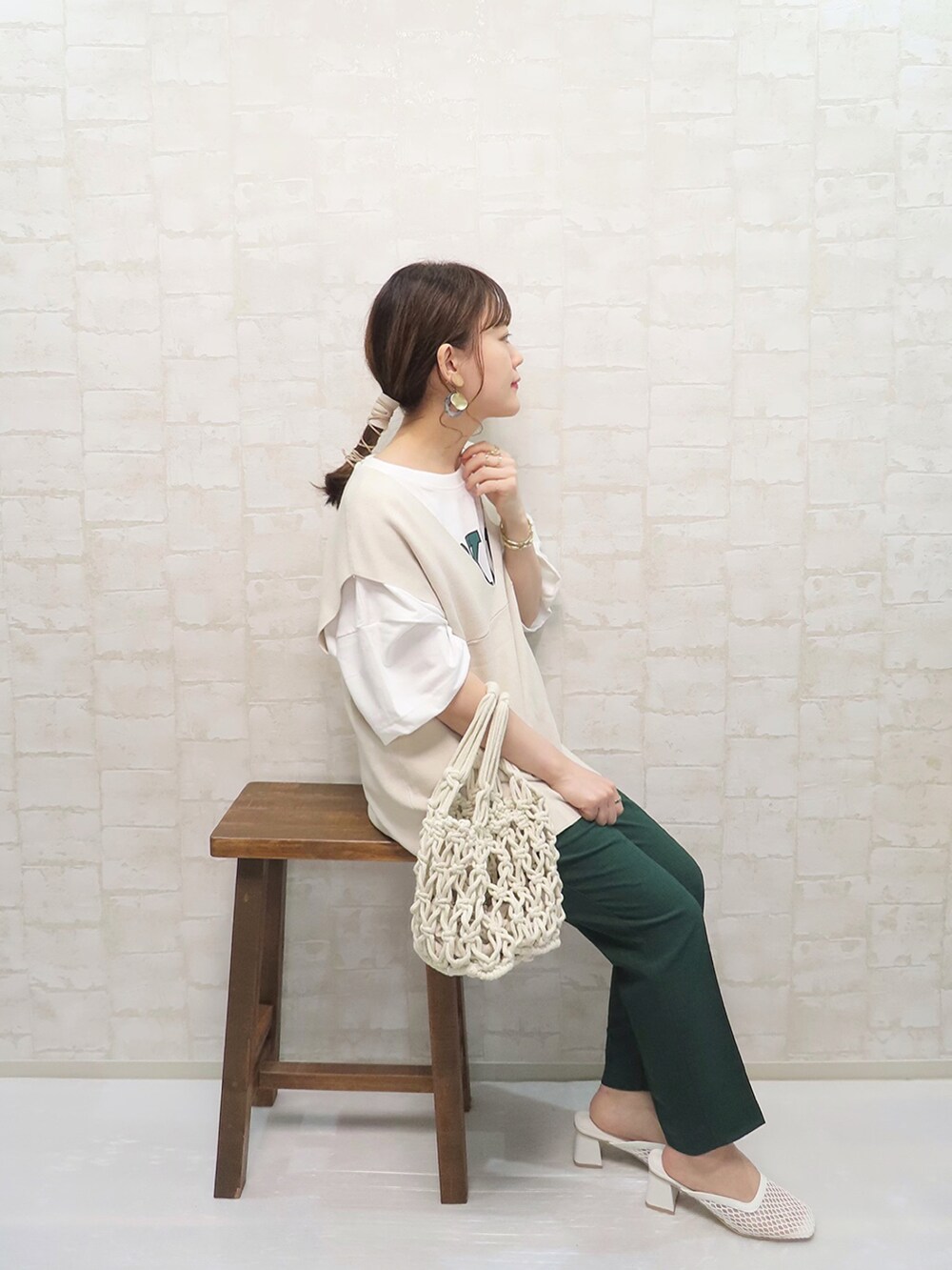 グリーン系のその他パンツ、ホワイト系のハンドバッグ、ホワイト系のサンダルを着用したレディースの春コーディネートの4枚目の写真