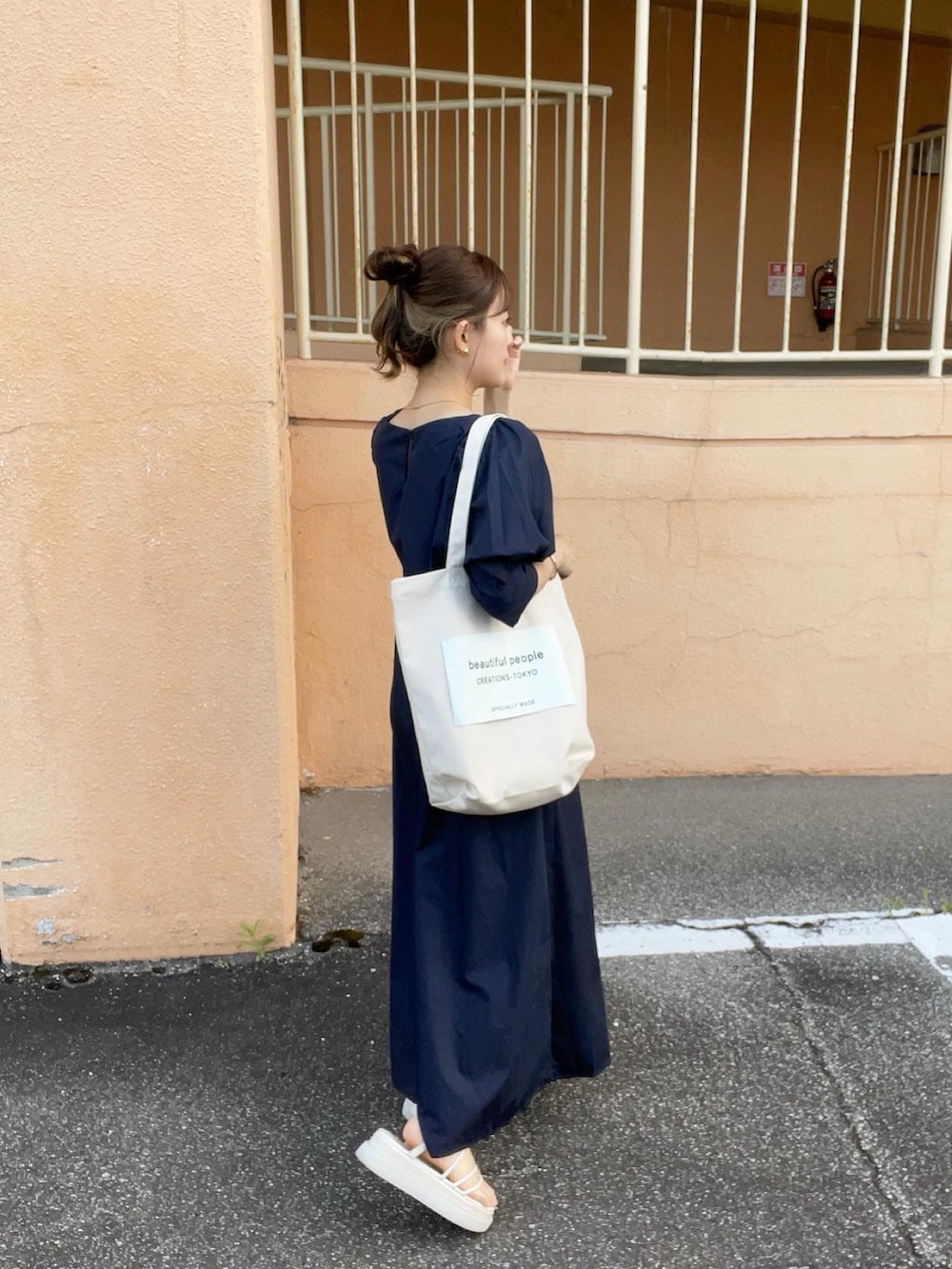 ブルー系のワンピース、ホワイト系のトートバッグ、ホワイト系のサンダルを着用したレディースの夏コーディネートの5枚目の写真