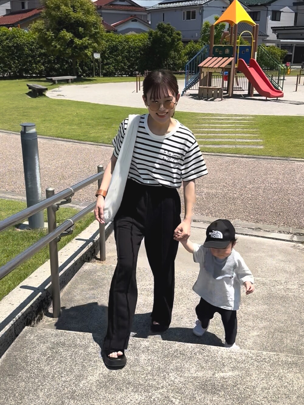 ホワイト系のTシャツ/カットソー、ブラック系のスウェットパンツ、ホワイト系のバッグを着用したレディースの夏コーディネートの3枚目の写真