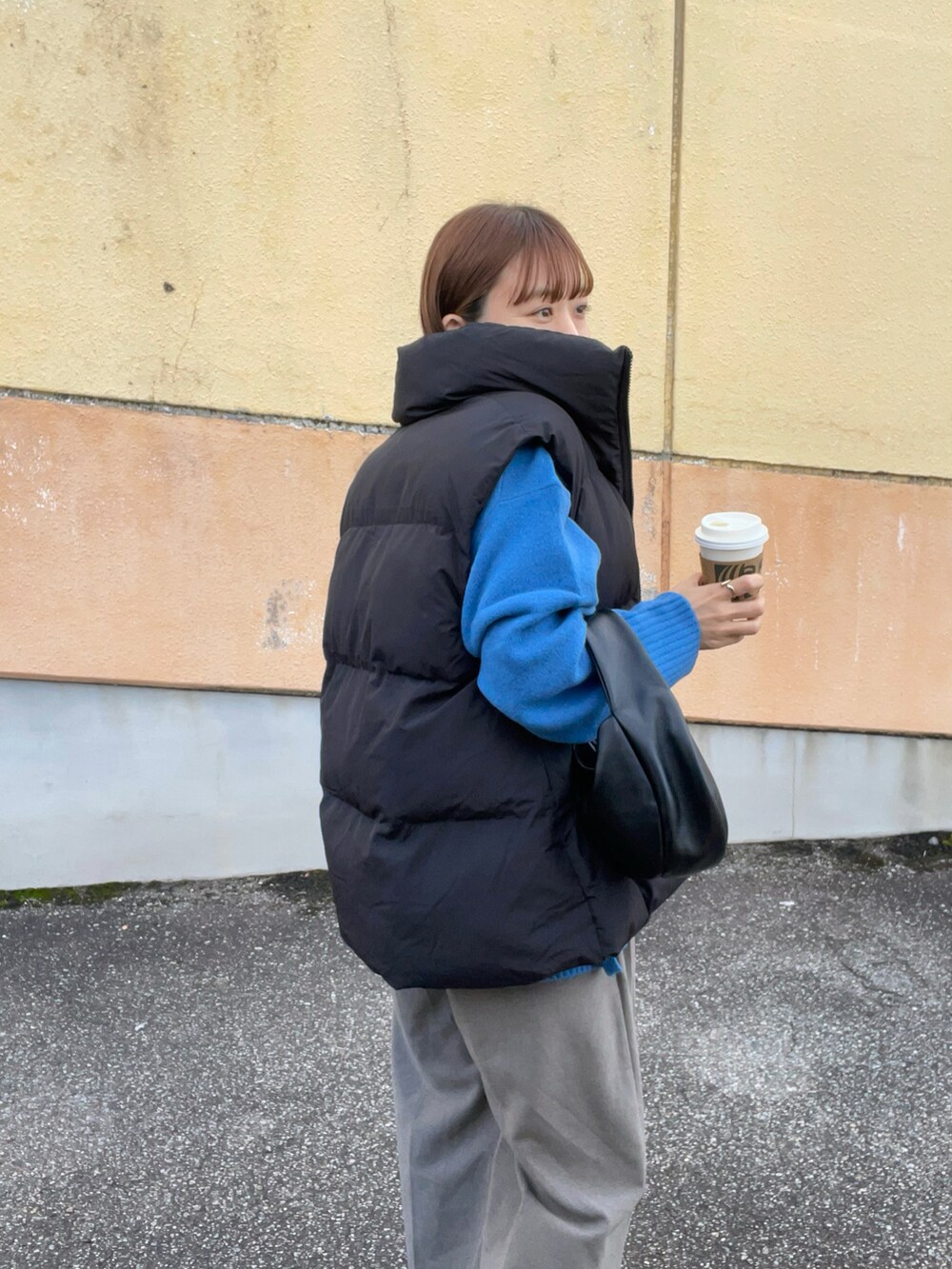 ブルー系のニット/セーター、ブラック系のベスト、ブラウン系のパンツを着用したレディースの秋コーディネートの2枚目の写真