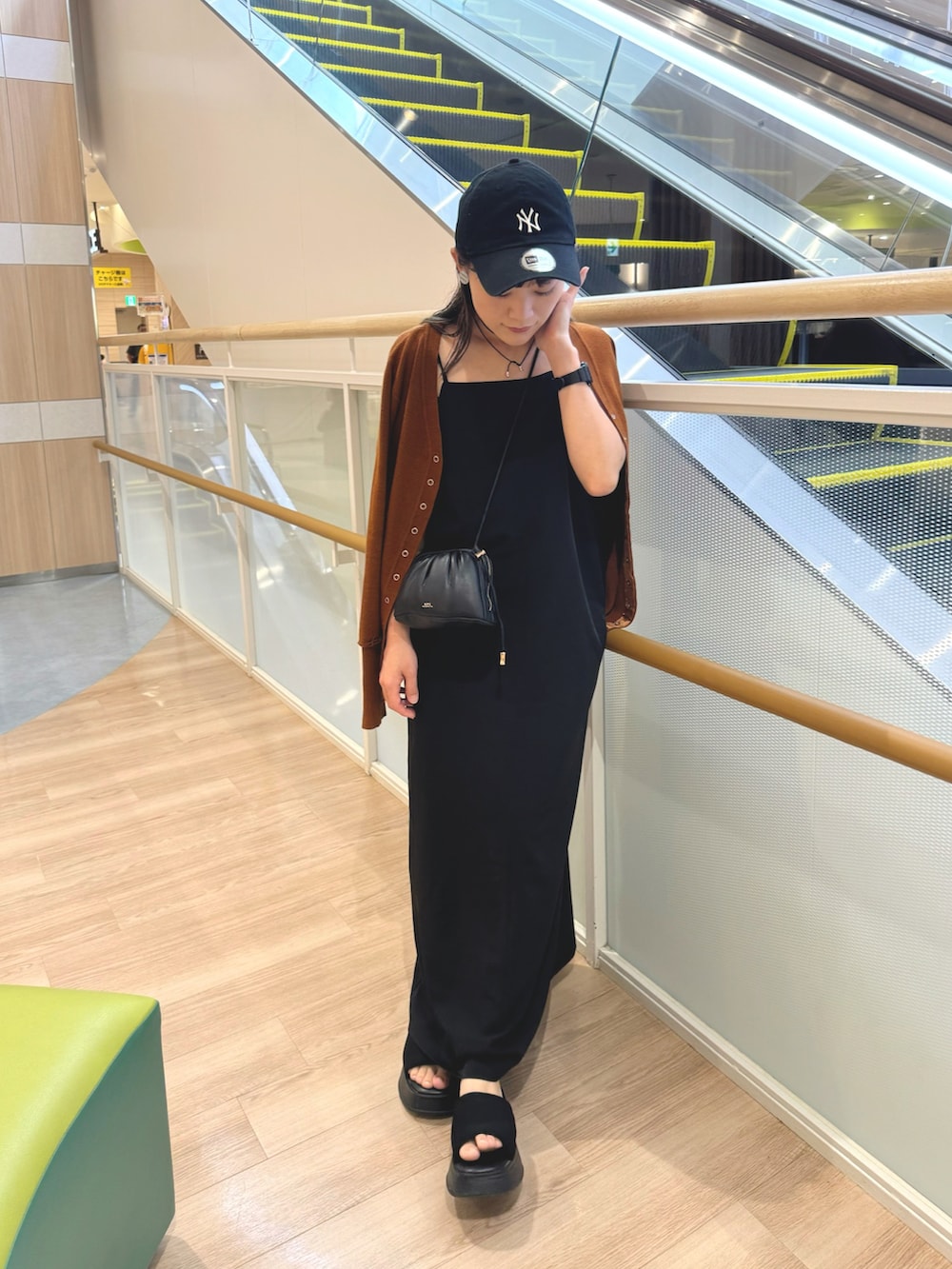 イエロー系のカーディガン/ボレロ、ブラック系のワンピース、ブラック系のショルダーバッグを着用したレディースの夏コーディネートの3枚目の写真