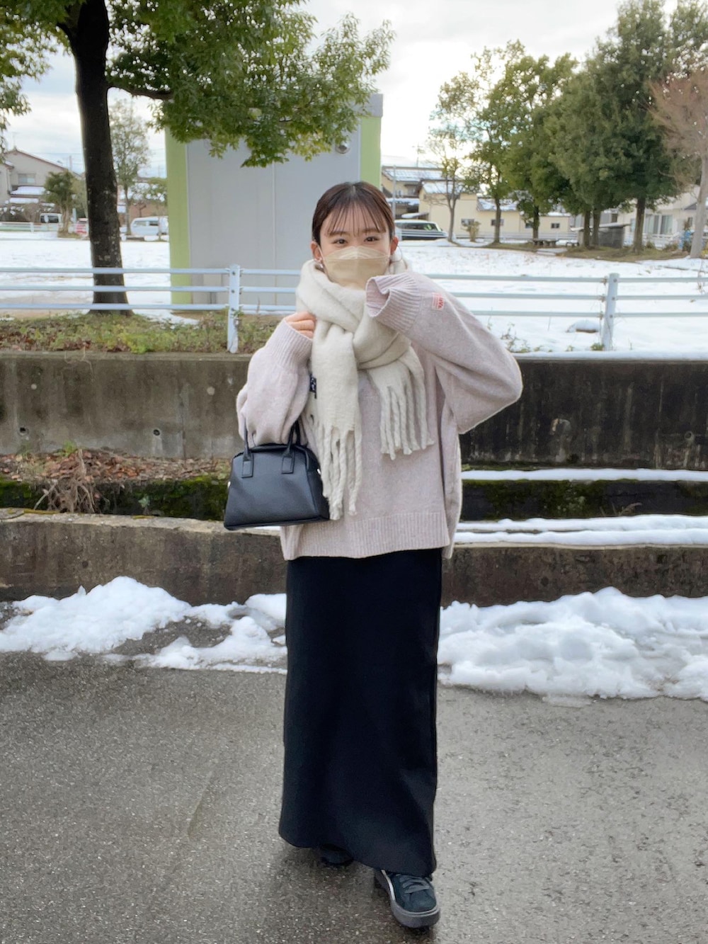 ピンク系のニット/セーター、ホワイト系のニット/セーター、ブラック系のスカートを着用したレディースの冬コーディネートの2枚目の写真