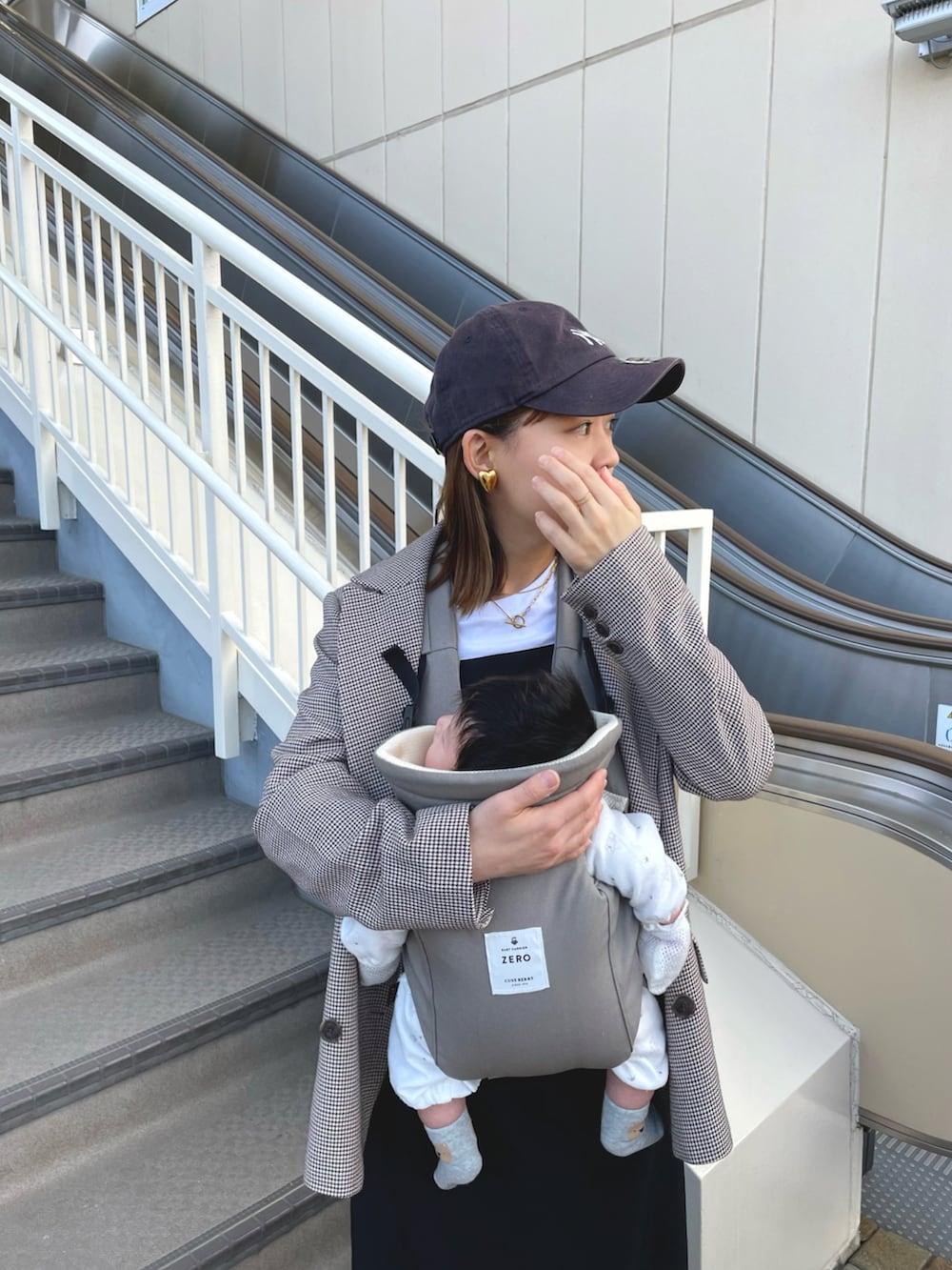 ブラウン系のテーラードジャケット、ブラック系のワンピース、ホワイト系のスニーカーを着用したレディースの冬コーディネートの5枚目の写真