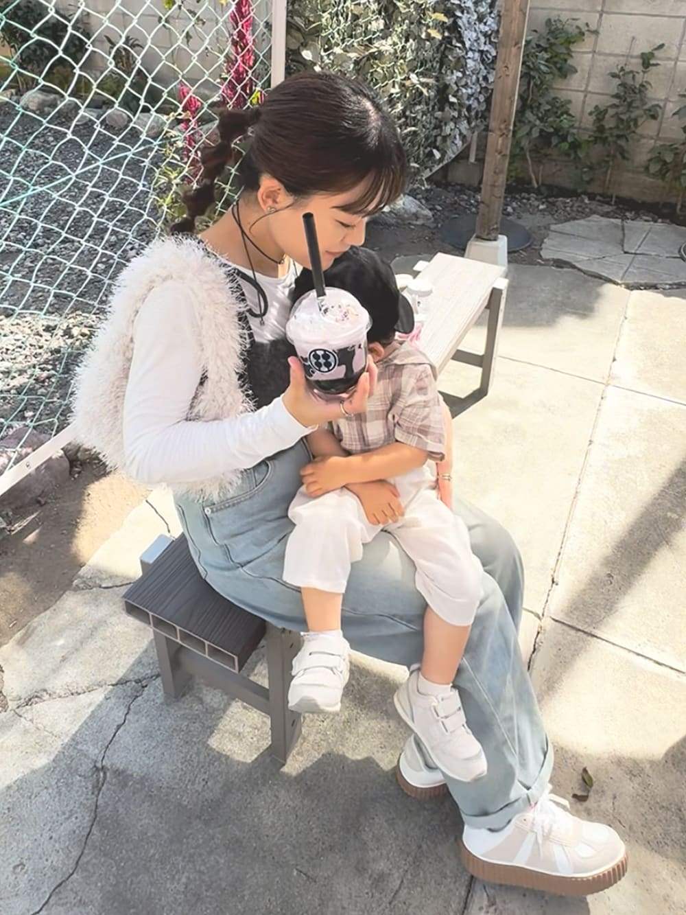 グレー系のカーディガン/ボレロ、ブルー系のデニムパンツ、ホワイト系のバッグを着用したレディースの秋コーディネートの3枚目の写真