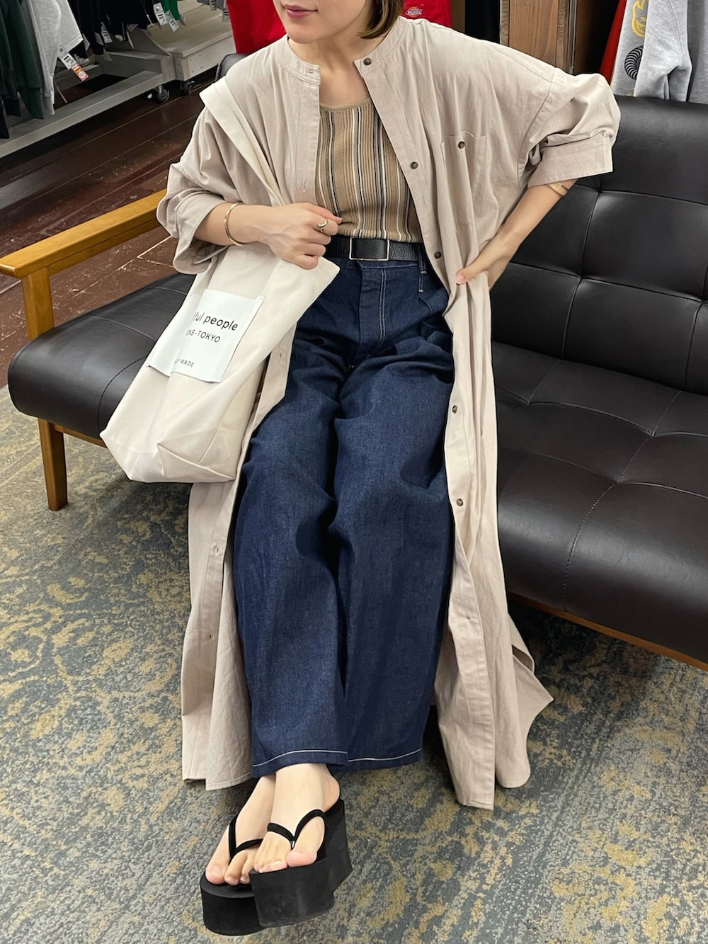 グレー系のシャツワンピース、ホワイト系のトートバッグ、ベージュ系のタンクトップを着用したレディースの夏コーディネートの3枚目の写真