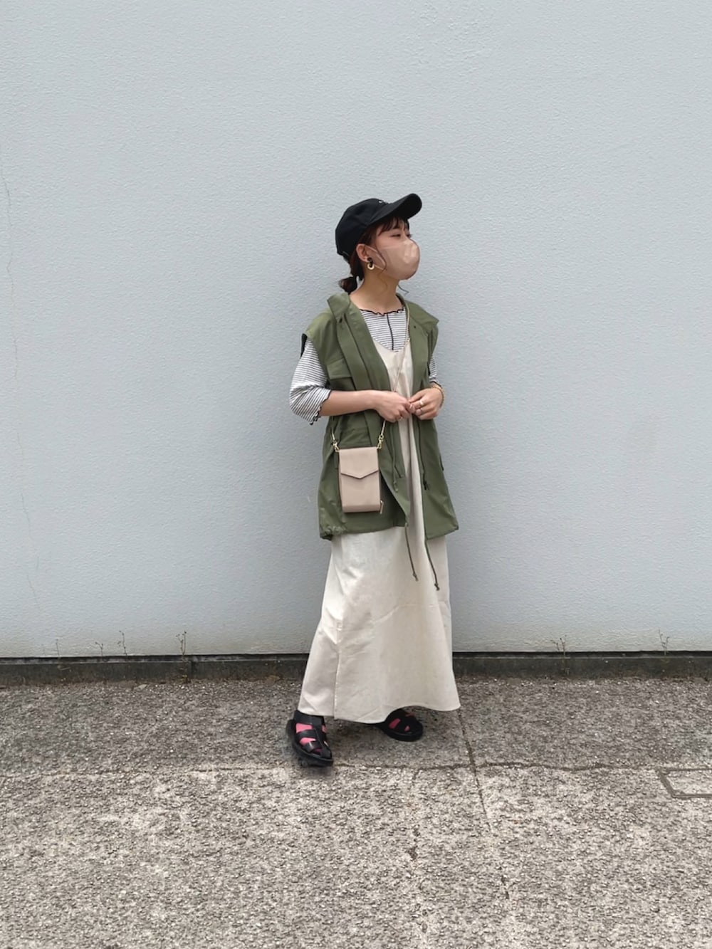 グリーン系のワンピース、ホワイト系のTシャツ/カットソー、グリーン系のベストを着用したレディースの春コーディネートの3枚目の写真