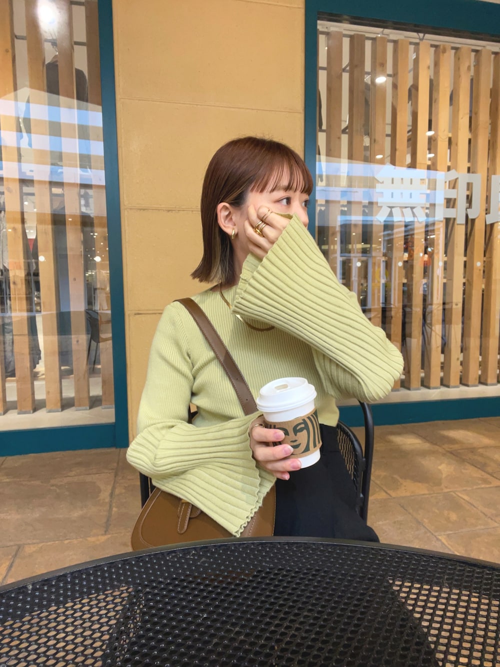 グリーン系のニット/セーター、ホワイト系のベスト、ブラック系のパンツを着用したレディースの秋コーディネートの4枚目の写真