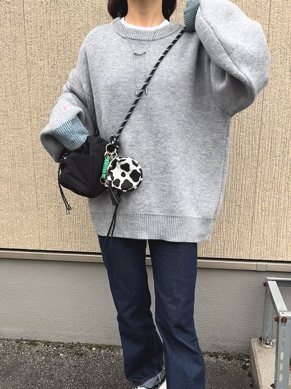 グレー系のニット/セーター、ブルー系のデニムパンツ、ブラック系のスニーカーを着用したレディースの冬コーディネートの4枚目の写真