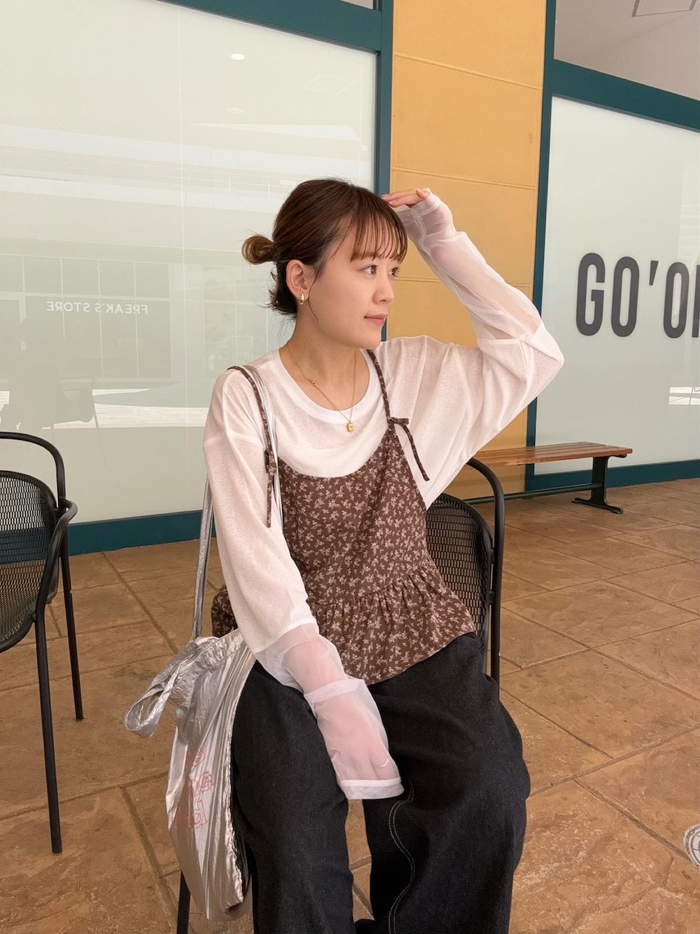 ブラウン系のシャツ/ブラウス、ホワイト系のTシャツ/カットソー、ブラック系のデニムパンツを着用したレディースの春コーディネートの4枚目の写真