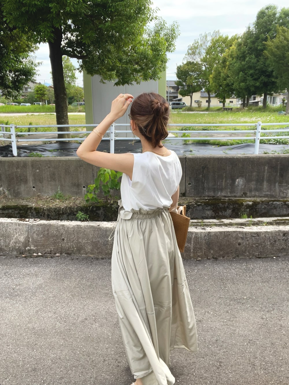 グリーン系のワンピース、ベージュ系のショルダーバッグ、ホワイト系のサンダルを着用したレディースの夏コーディネートの4枚目の写真