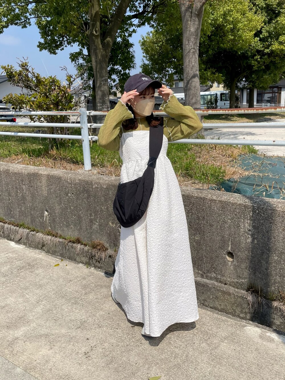 ホワイト系のワンピース、グリーン系のTシャツ/カットソー、ブラック系のショルダーバッグを着用したレディースの春コーディネートの4枚目の写真