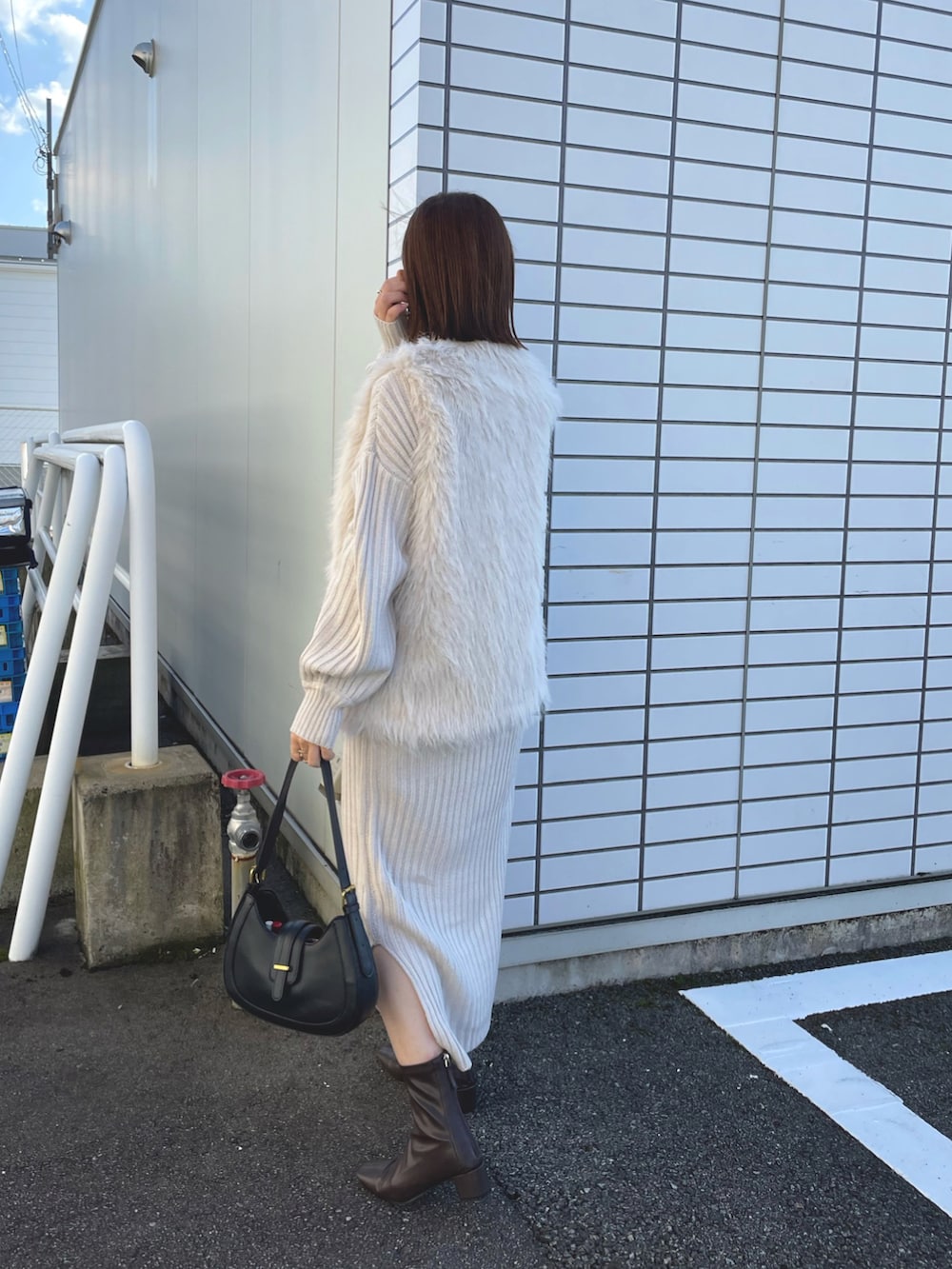 ホワイト系のベスト、ホワイト系のワンピース/ドレス、ブラック系のバッグを着用したレディースの秋コーディネートの3枚目の写真