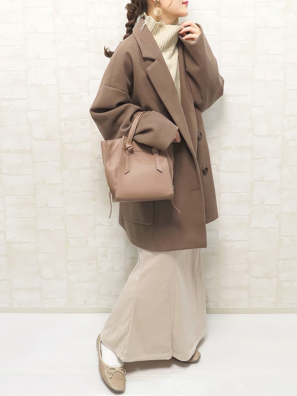 ブラウン系のその他アウター、ベージュ系のニット/セーター、ホワイト系のスカートを着用したレディースの秋コーディネートの2枚目の写真