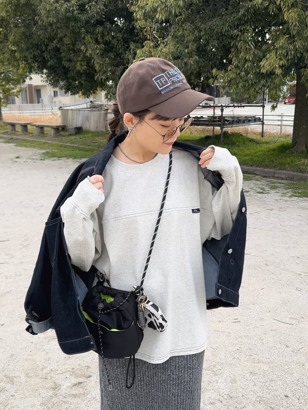 ベージュ系のTシャツ/カットソー、ベージュ系のスニーカー、グレー系のスカートを着用したレディースの春コーディネートの2枚目の写真